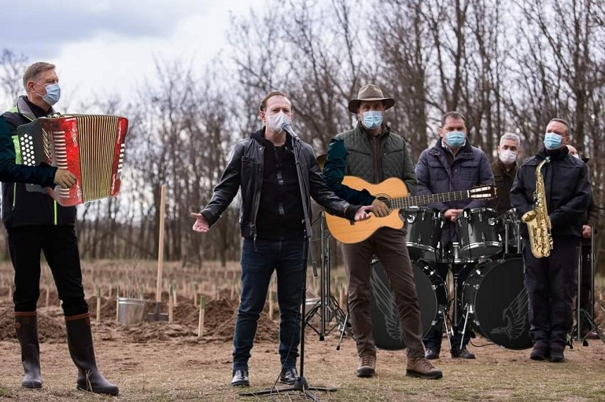 Prim-ministrul Cîţu, protagonist de meme după acţiunea de împădurire – Pe aceeaşi scenă cu Metallica şi „urmărit” de Bernie Sanders – FOTO